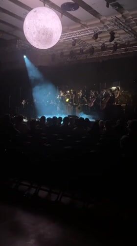 Orchestra performs with moon prop in Colchester concert hall