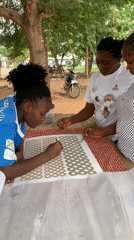 Women craft with metallic items outdoors in Maigizo, Nigeria
