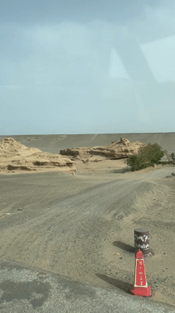 Vehicle travels desert road near Dunhuang City, China