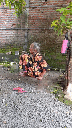 Elderly woman spends quiet moments in Baron yard