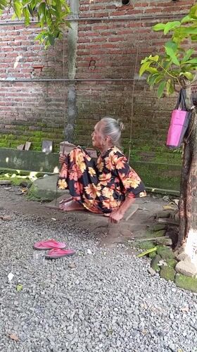 Elderly woman spends quiet moments in Baron yard