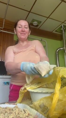 Woman conducts early morning kitchen activities in Talmenka, Russia