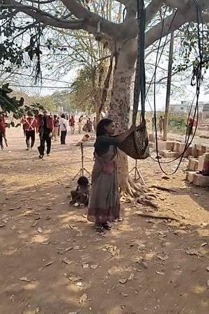 Woman hangs basket from tree as marching band passes