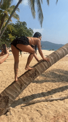 Woman climbs palm tree, performs ballet on Thai beach