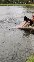 Morning fish feeding draws families to Thai lake