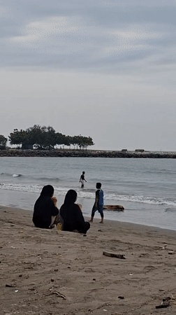 Cloudy morning at a Lhokseumawe beach, shells and shoreline.