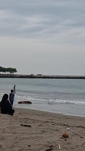 Cloudy morning at a Lhokseumawe beach, shells and shoreline.