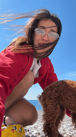 Woman plays with brown dog on Montenegro beach