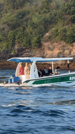 Boat tour passing Nusa Penida's rocky coastal arches