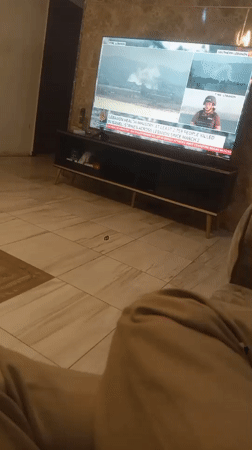 Resident watches international news while dining at home in Nigeria