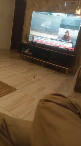 Resident watches international news while dining at home in Nigeria