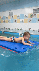 Child paddles on foam float in Russian pool