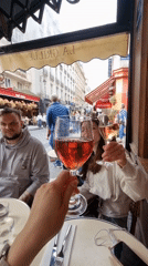 Parisians toast with rose wine at street cafe