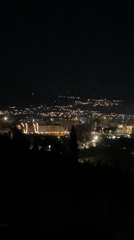 Nighttime aerial footage captures illuminated cityscape in Šušanj, Montenegro