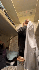 Woman makes bed in Russian train compartment