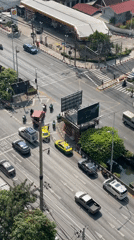 Bangkok intersection bustling with traffic on sunny April morning