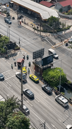 Bangkok intersection bustling with traffic on sunny April morning