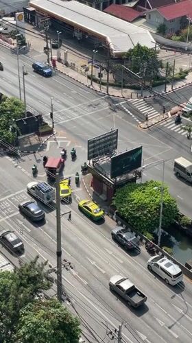 Bangkok intersection bustling with traffic on sunny April morning