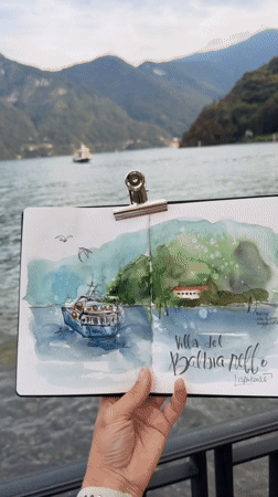 Watercolor sketchpad open to a Lake Como boat painting