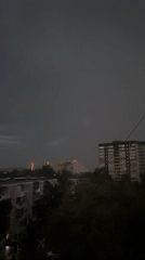 Lightning storm breaks over a city at dusk
