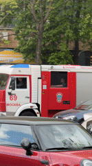Moscow fire truck navigates heavy traffic past restaurant