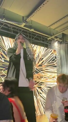 Live stage performance in Novaya Usman' with geometric gold backdrop