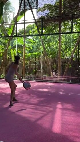 Woman plays padel tennis on pink court in Philippines