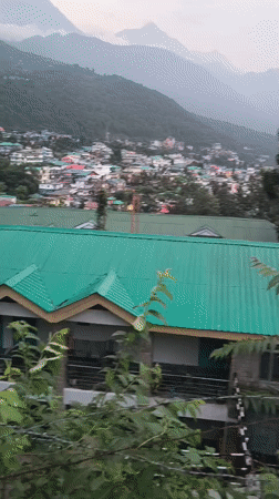 Rainy afternoon in Dharamshala, hillside town under mountain mist