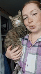 Woman cuddles tabby cat in casual morning moment