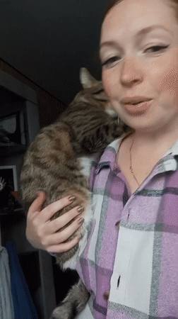 Woman cuddles tabby cat in casual morning moment