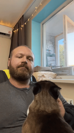 Man enjoys quiet moment with cat in Noviy, Russia