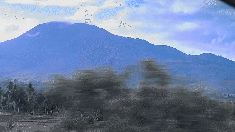 Mountain range filmed from moving vehicle in Lonbaroh, Indonesia