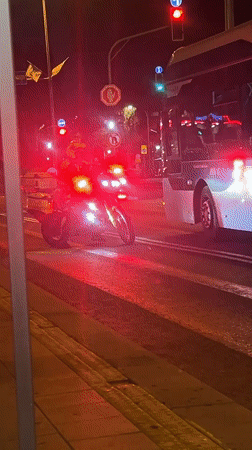 Motorcycle, bus wait at red light in Kiryat Bialik