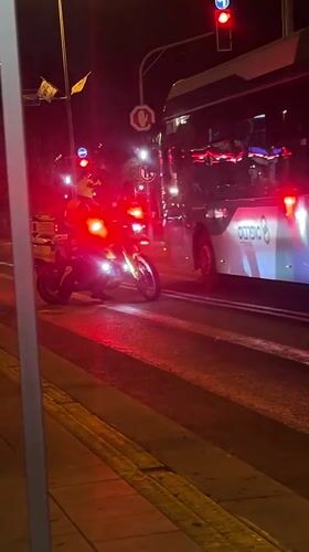 Motorcycle, bus wait at red light in Kiryat Bialik
