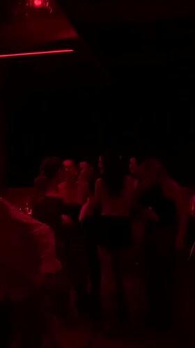 Evening social gathering at red-lit Dubai nightclub captured