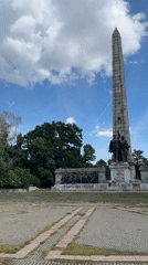 Visitors enjoy sunny afternoon at memorial park with pond