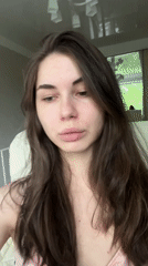 Woman adjusts hair, touches forehead in Saint Petersburg moment