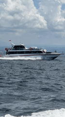 Indonesian-flagged boat speeds across choppy ocean waters