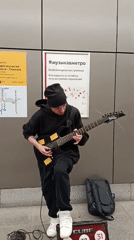 Street musician plays electric guitar in Moscow subway station
