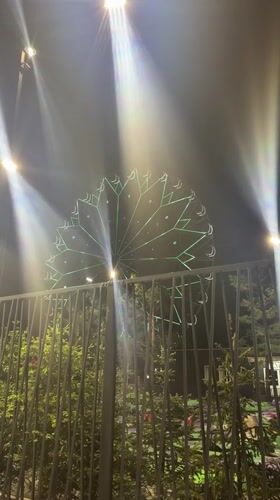 Illuminated Ferris wheel operates during evening hours in Omsk