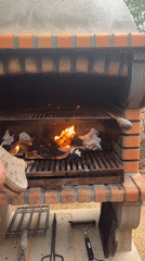 Person tends fire in brick oven, Benitachell Spain