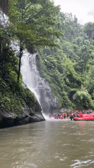 Life-jacketed group gathers at waterfall base in Payangan, Indonesia