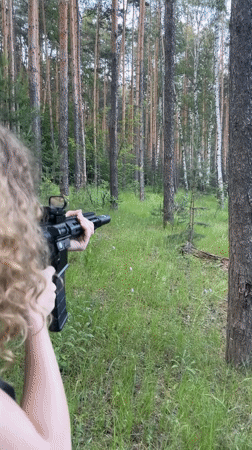 Woman photographed with rifle in Russian forest clearing