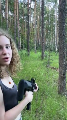 Woman photographed with rifle in Russian forest clearing