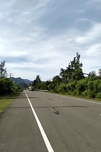 Tropical road documented in Meunasahmesjid under overcast skies
