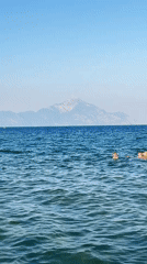 A calm beach afternoon in Toroni, waves erasing a name in the sand.