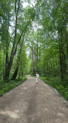 Woman walks forest path in Izhevsk, Russia