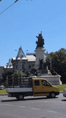 Busy Bucharest street corner with monuments, traffic, and construction