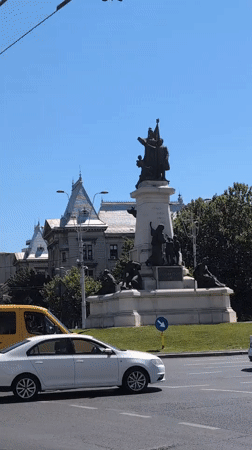 Busy Bucharest street corner with monuments, traffic, and construction