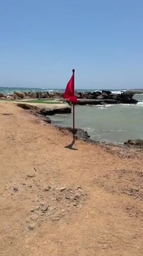 Busy summer day at Nissi Beach, Ayia Napa, rough seas flagged